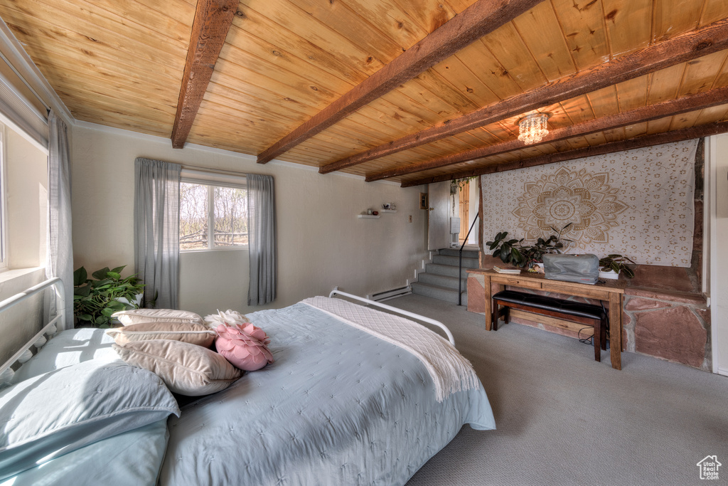 Carpeted bedroom with beamed ceiling, baseboard heating, and wood ceiling