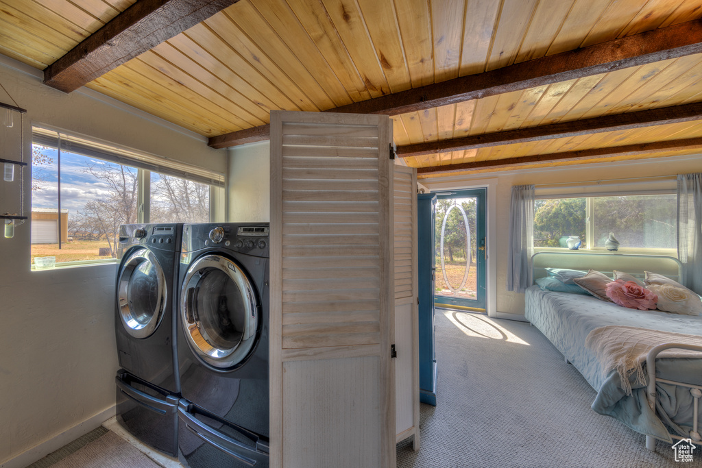 Clothes washing area with carpet floors, wooden ceiling, and washer and dryer