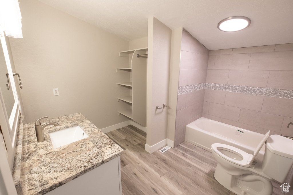 Bathroom featuring vanity, hardwood / wood-style flooring, toilet, and a textured ceiling