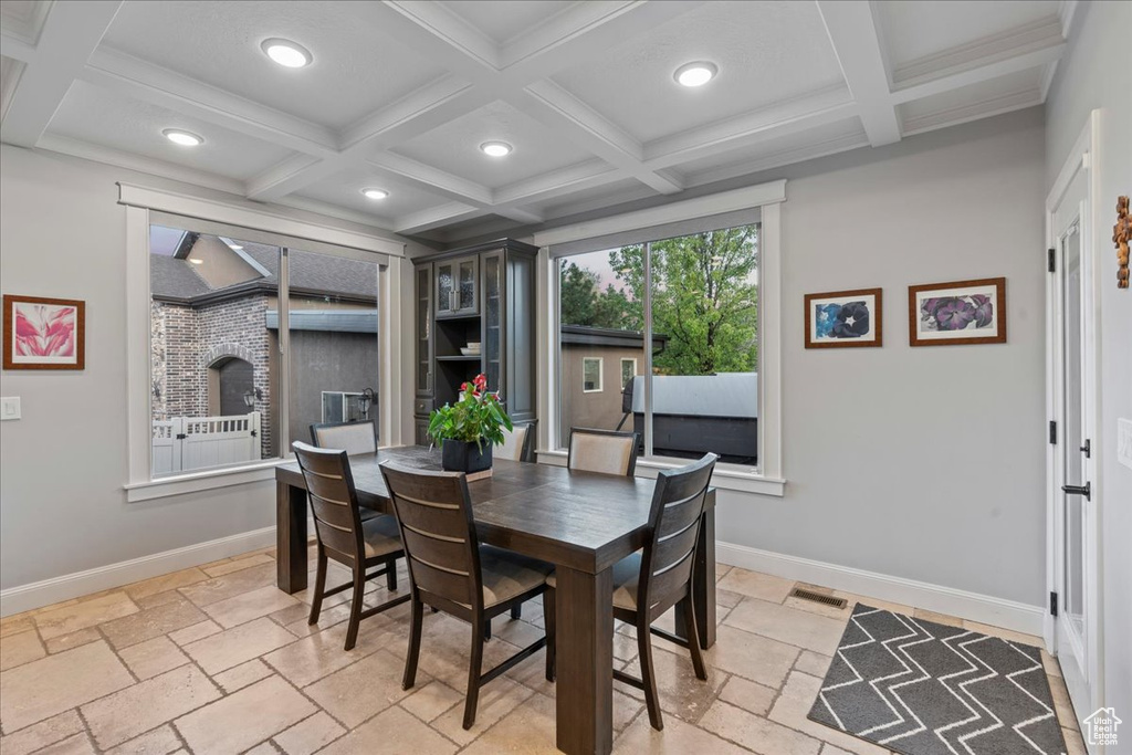 Dining space with beamed ceiling, coffered ceiling, and light tile floors