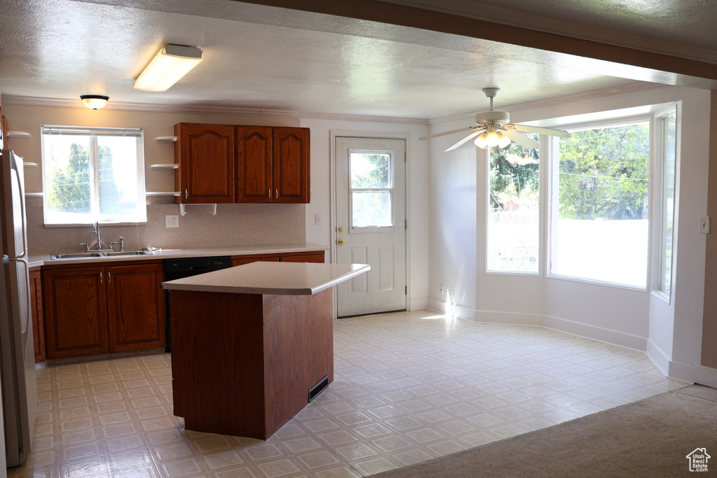 Kitchen with a center island, a healthy amount of sunlight, ceiling fan, and sink