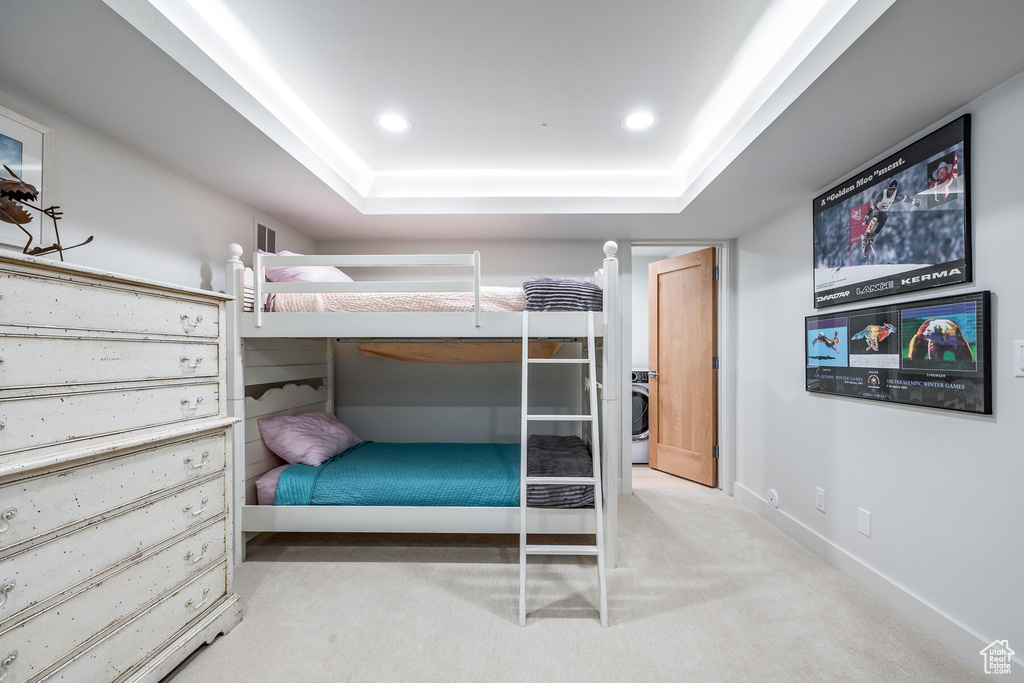 Bedroom with carpet floors and a raised ceiling