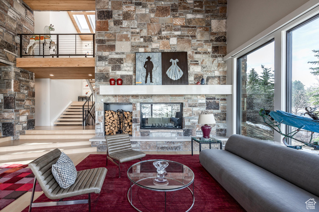 Living room featuring a wealth of natural light, a towering ceiling, and a fireplace