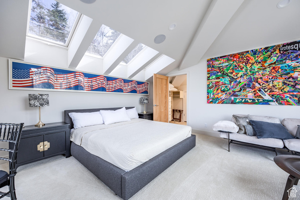 Bedroom with a skylight, carpet, and high vaulted ceiling
