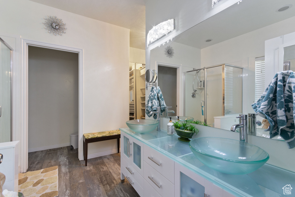Bathroom with walk in shower, wood-type flooring, and dual vanity