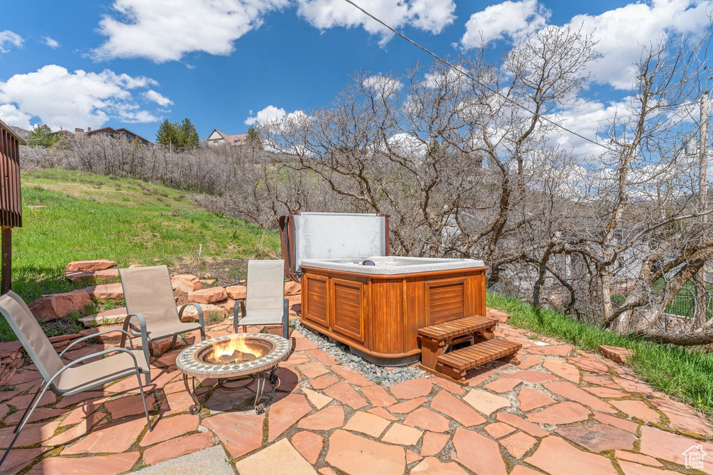 View of terrace with a fire pit and a hot tub