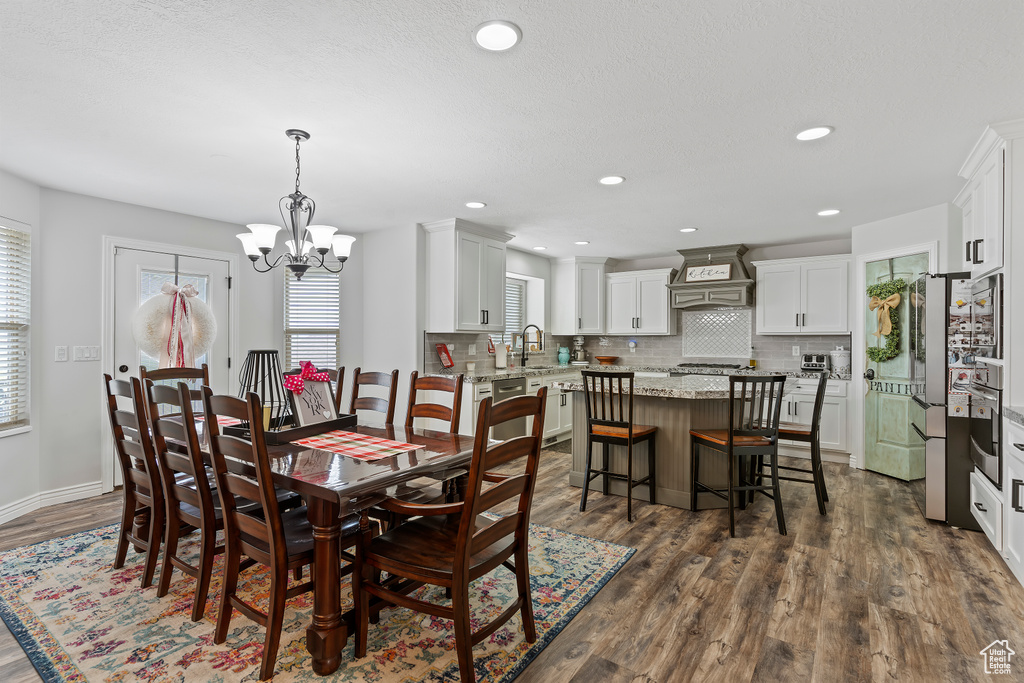 Dining space featuring an inviting chandelier, dark hardwood / wood-style flooring, and sink
