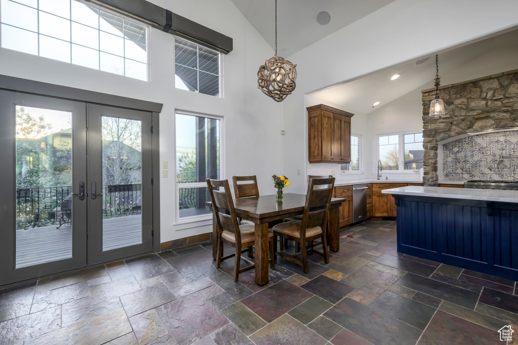 Dining area featuring a wealth of natural light, french doors, dark tile flooring, and high vaulted ceiling