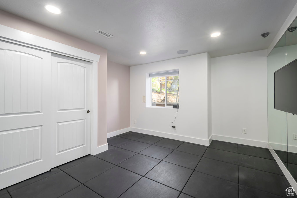 Interior space featuring a closet and dark tile floors