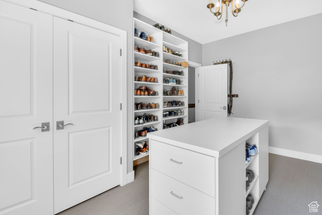 Walk in closet featuring carpet floors and an inviting chandelier