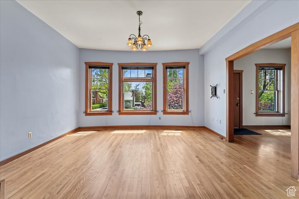Spare room featuring light hardwood / wood-style floors and a chandelier