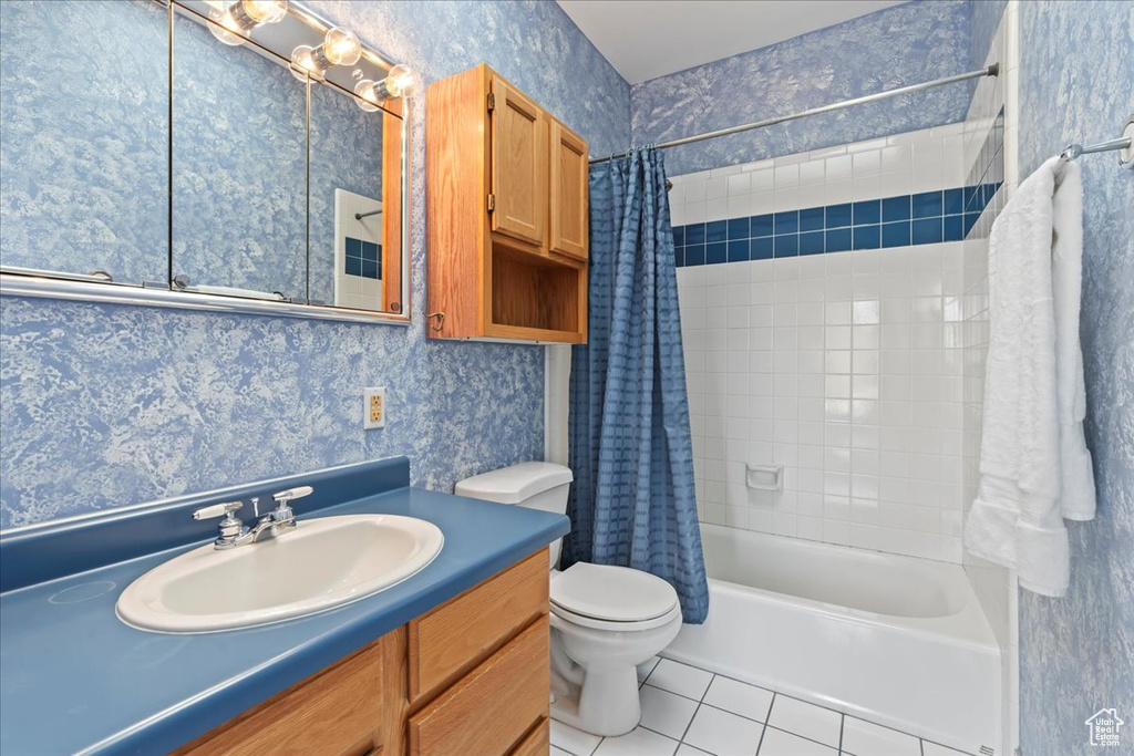 Full bathroom with vanity with extensive cabinet space, shower / tub combo, toilet, and tile flooring