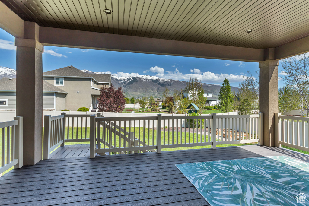 Deck featuring a mountain view and a lawn