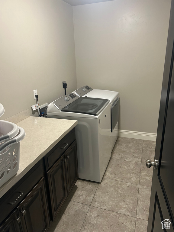 Washroom with cabinets, light tile flooring, washer and dryer, and electric dryer hookup