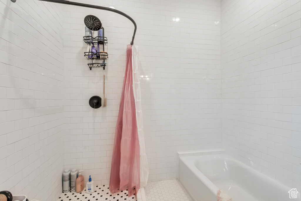 Bathroom featuring tile flooring and shower / bath combination with curtain