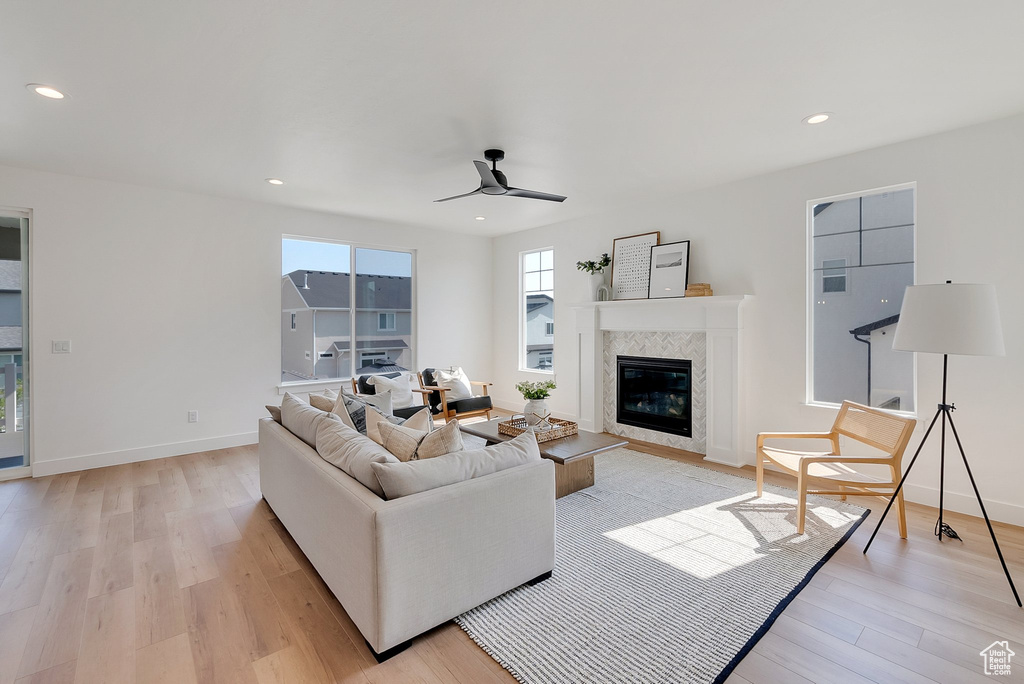 Living room with light hardwood / wood-style floors and ceiling fan