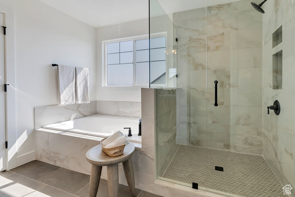 Bathroom with independent shower and bath and tile patterned flooring