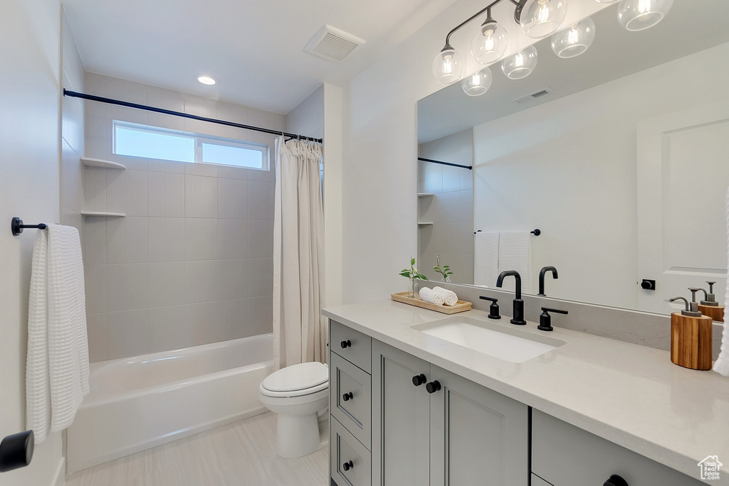 Full bathroom featuring tile patterned floors, shower / bathtub combination with curtain, toilet, and vanity