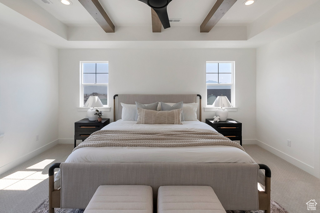 Carpeted bedroom featuring beam ceiling, multiple windows, and ceiling fan