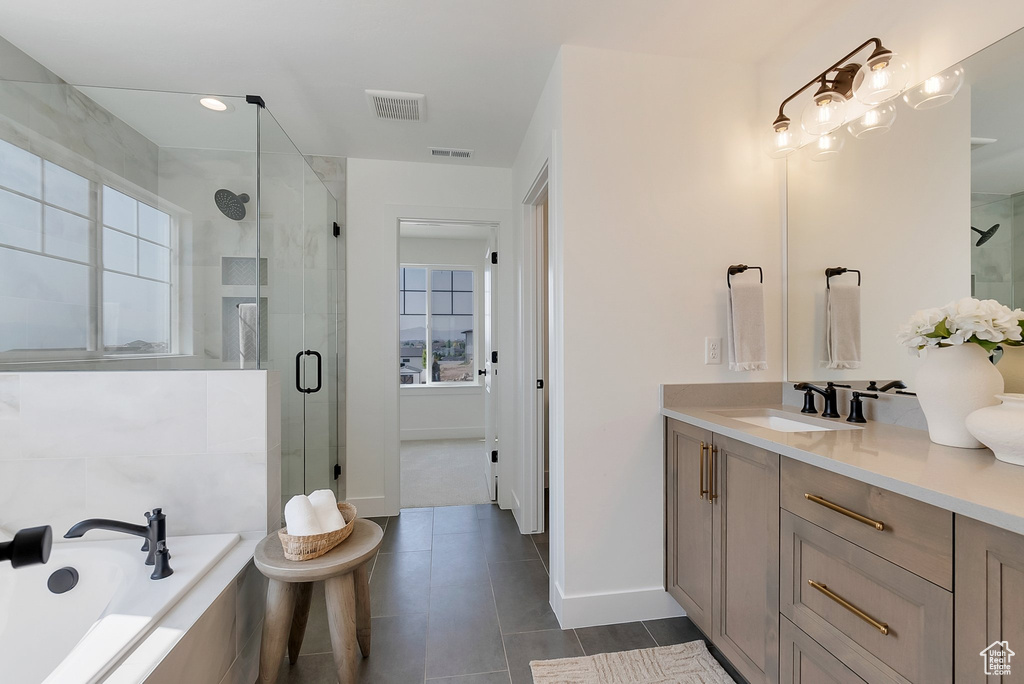 Bathroom with vanity, tile patterned floors, and shower with separate bathtub