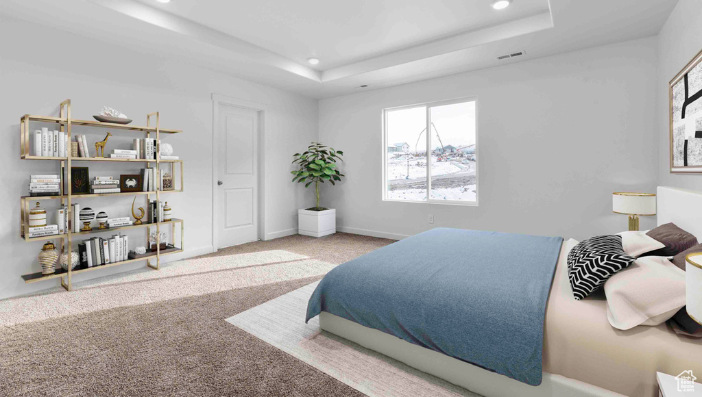 Bedroom with a raised ceiling and carpet flooring