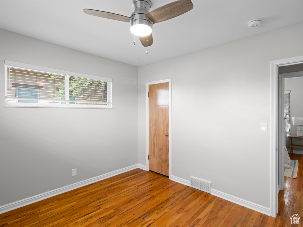 Unfurnished bedroom featuring hardwood / wood-style floors and ceiling fan