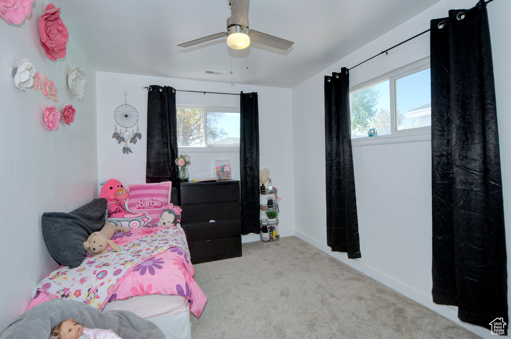 Bedroom featuring ceiling fan, carpet, and multiple windows