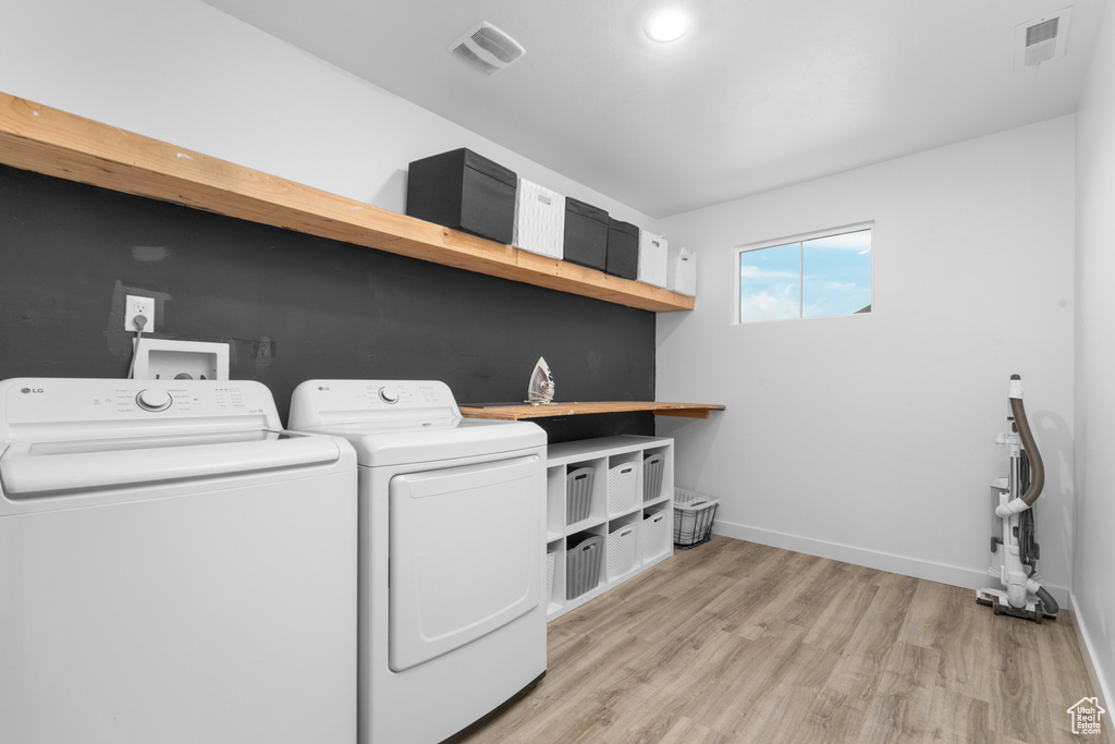 Washroom featuring independent washer and dryer and light hardwood / wood-style floors