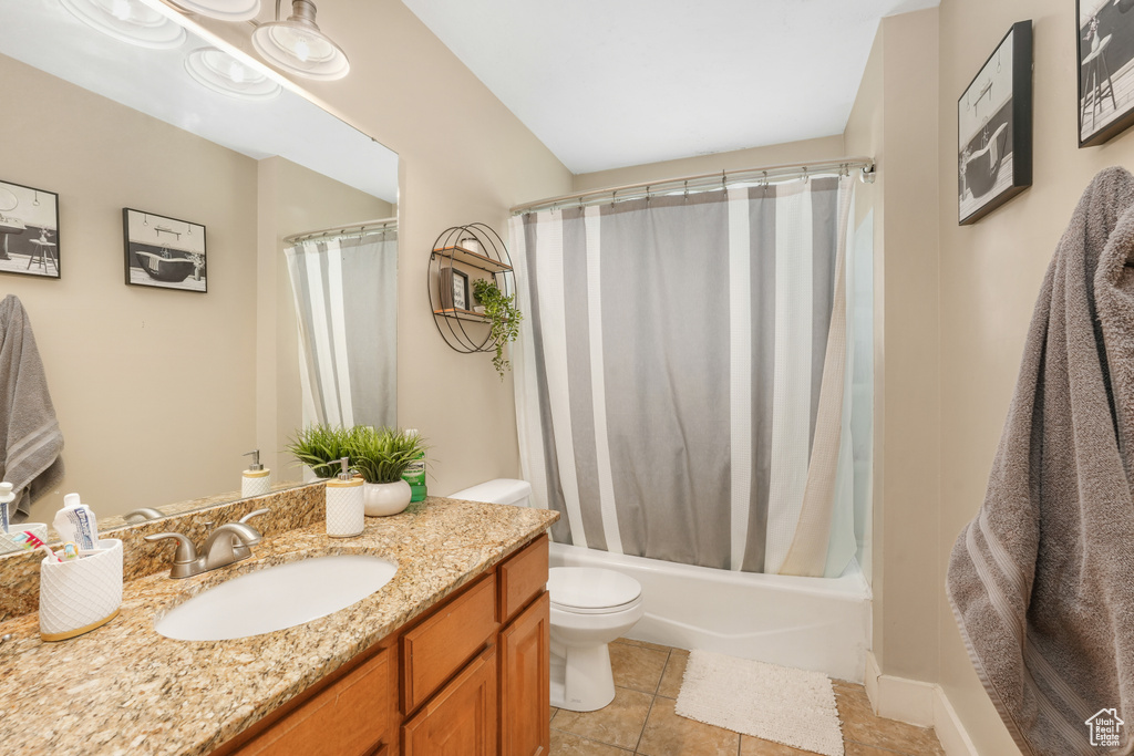 Full bathroom featuring vanity, tile floors, toilet, and shower / bath combo with shower curtain