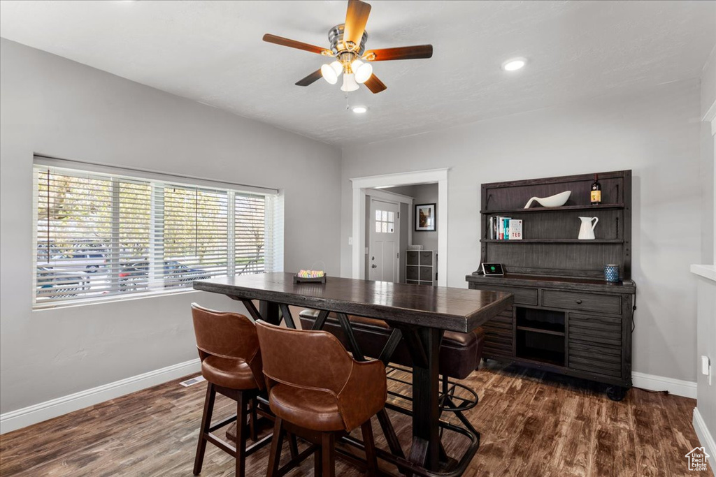 Dining room with dark hardwood / wood-style flooring and ceiling fan