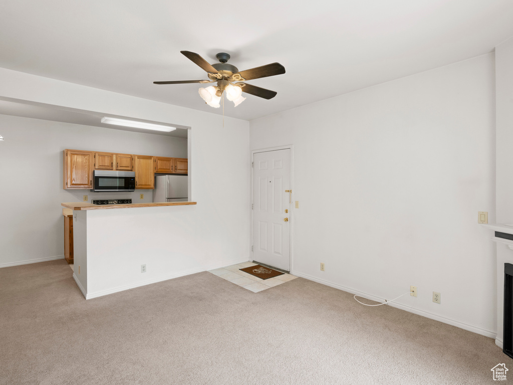Unfurnished living room with ceiling fan and light carpet