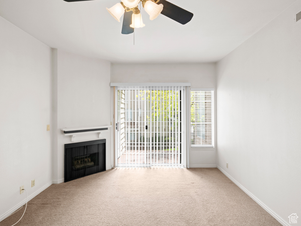 Unfurnished living room with ceiling fan and carpet floors