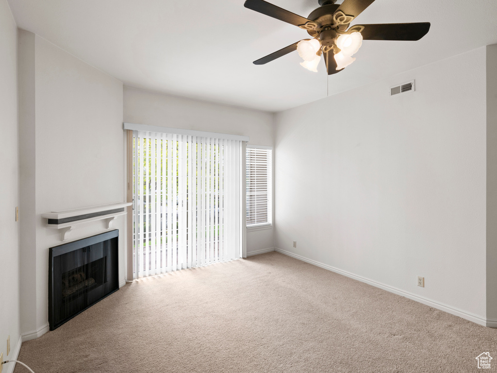 Unfurnished living room with ceiling fan and carpet