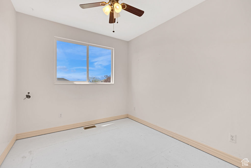 Spare room featuring concrete floors and ceiling fan