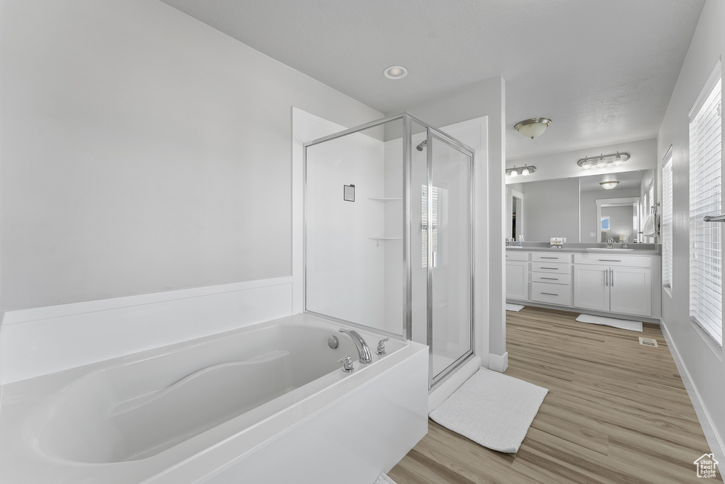 Bathroom featuring vanity, hardwood / wood-style flooring, and separate shower and tub