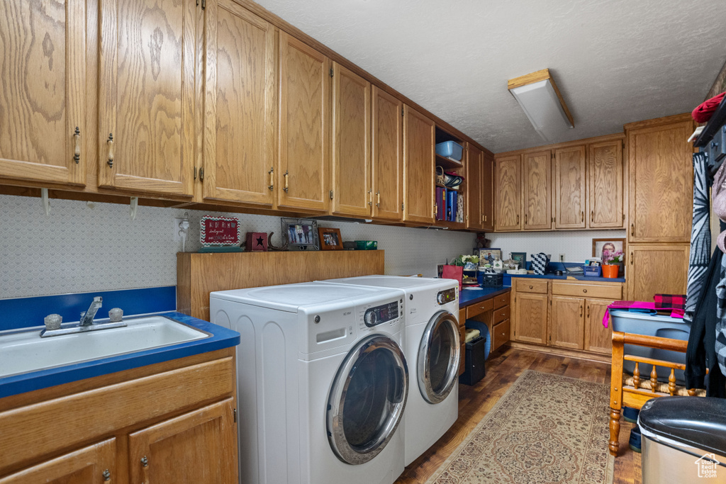 Laundry room featuring a textured ceiling, sink, and washer and clothes dryer