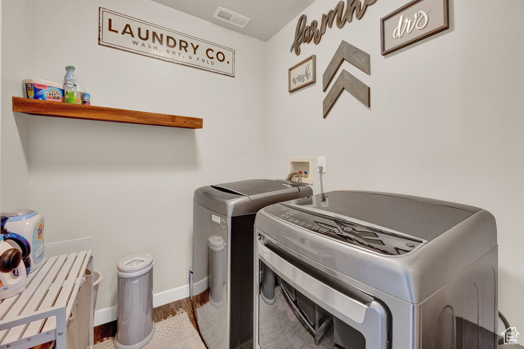 Laundry room featuring hookup for a washing machine, hardwood / wood-style floors, and washer and dryer