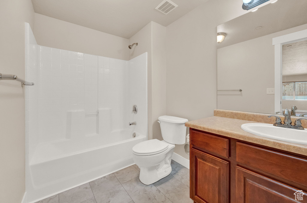Full bathroom featuring tile flooring, vanity, tub / shower combination, and toilet