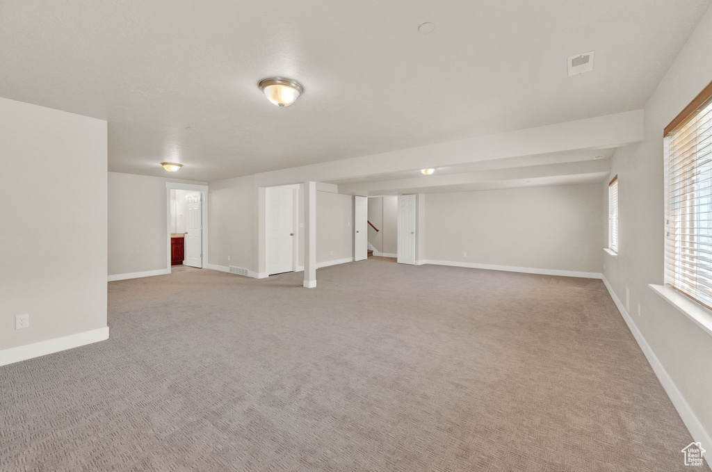 Basement featuring a healthy amount of sunlight and carpet flooring