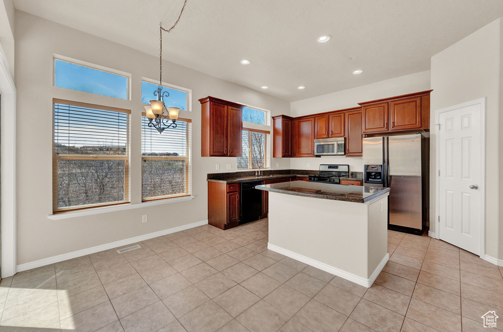 Kitchen with a center island, light tile floors, and stainless steel appliances