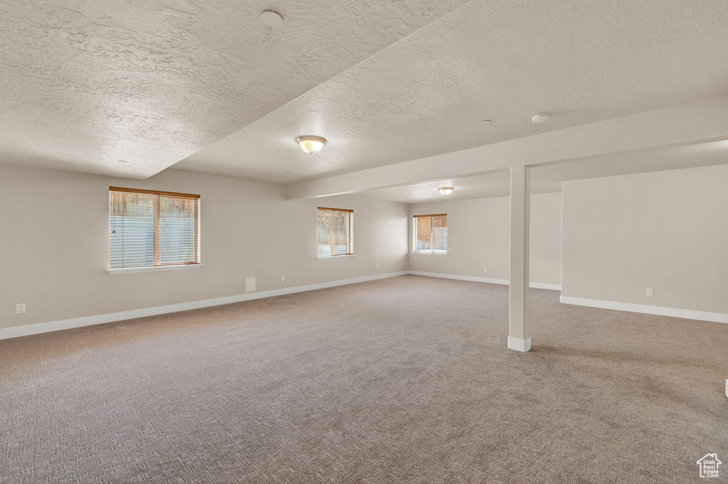 Interior space with carpet flooring and a textured ceiling