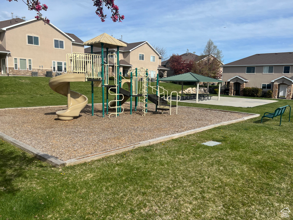 View of playground featuring a lawn and a gazebo