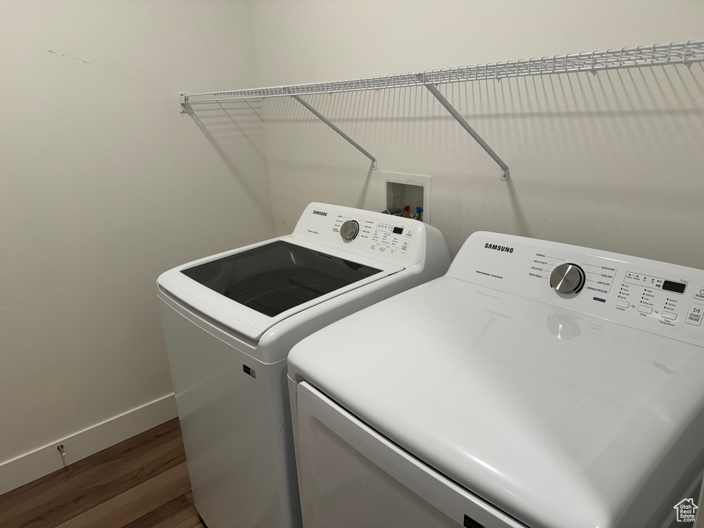 Clothes washing area with hardwood / wood-style floors, independent washer and dryer, and washer hookup