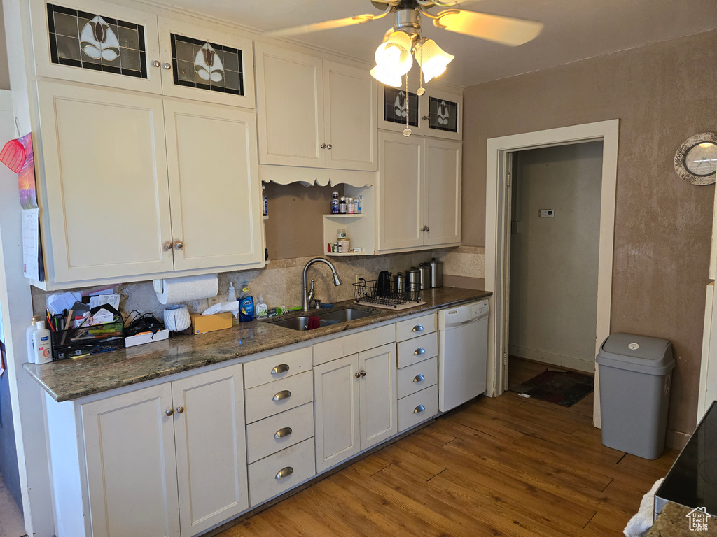 Kitchen with ceiling fan, white cabinets, sink, hardwood / wood-style flooring, and white dishwasher