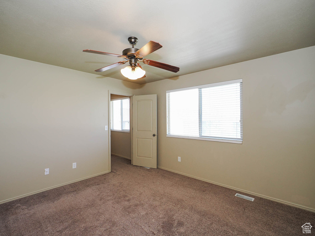 Spare room with ceiling fan and carpet floors