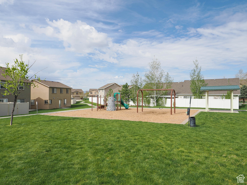 View of property's community with a playground and a lawn