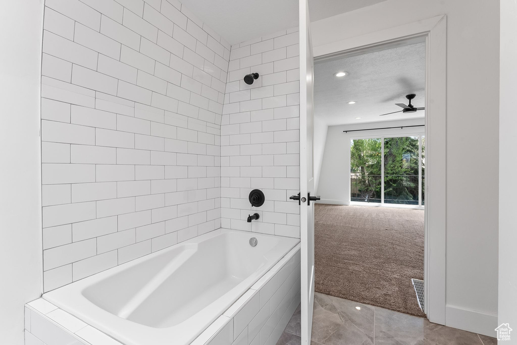 Bathroom with tiled shower / bath combo, ceiling fan, and tile floors