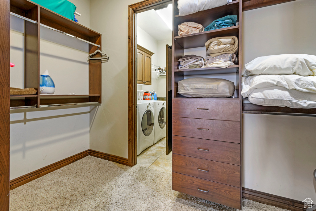 Walk in closet featuring washing machine and dryer and light tile flooring