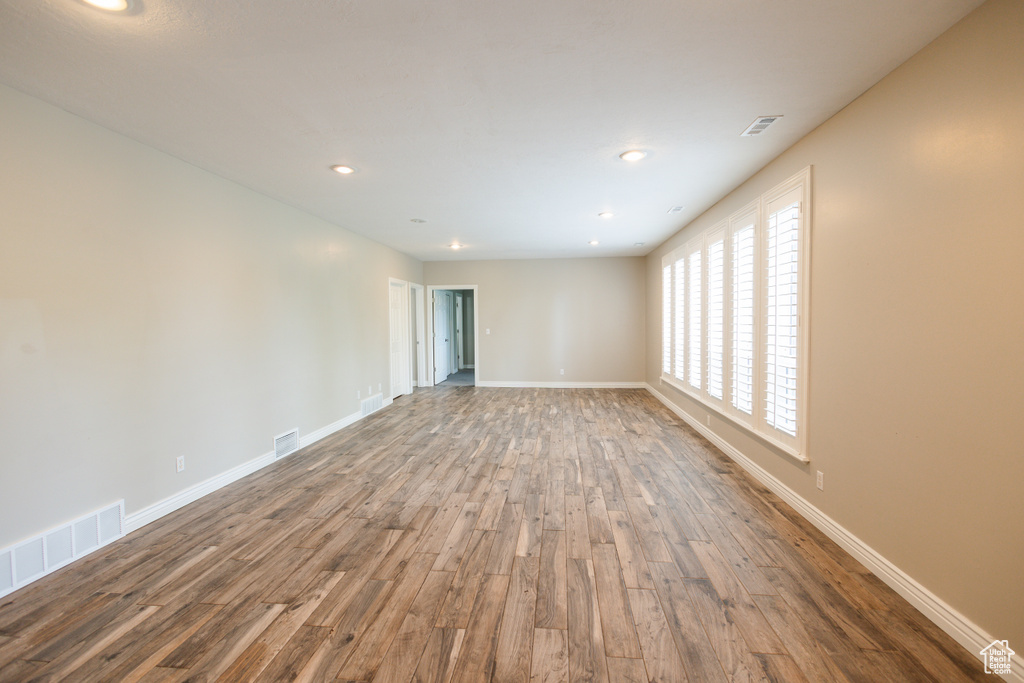 Unfurnished room featuring a healthy amount of sunlight and hardwood / wood-style flooring