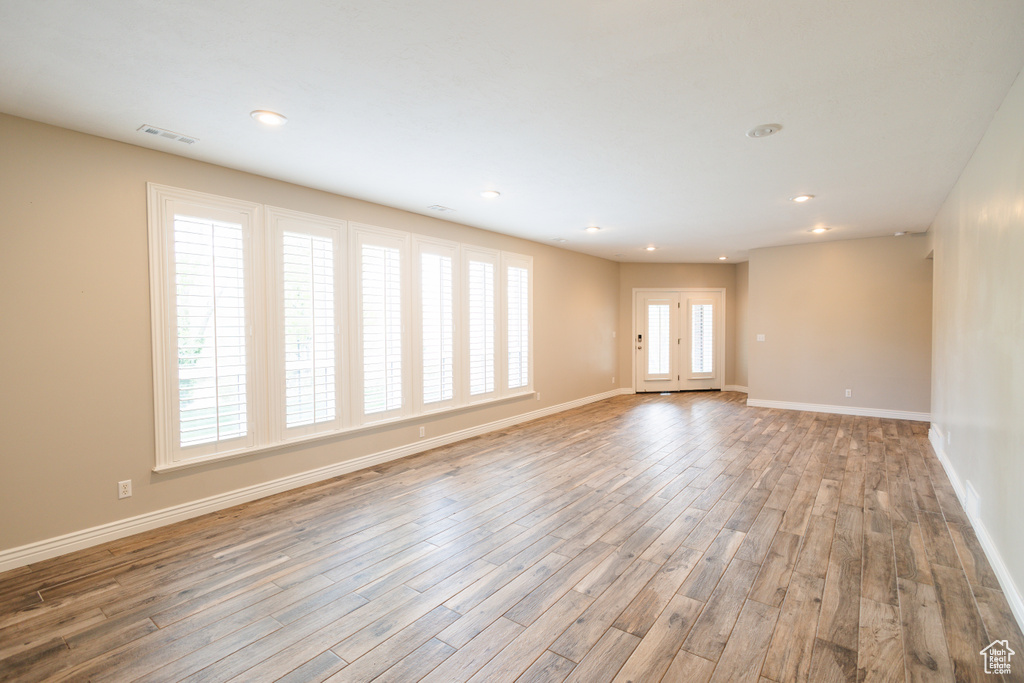 Unfurnished room featuring hardwood / wood-style floors and a wealth of natural light